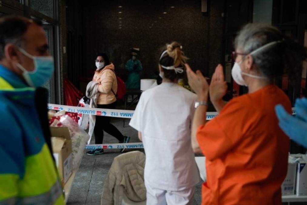 This handout picture released by the Comunidad de Madrid (Madrid's regional government) on March 31, 2020 shows healtcare workers applauding to patients who have recovered from the COVID-19 disease at the temporary hospital located at the Ifema convention and exhibition centre in Madrid. - Spain confirmed another 849 deaths in 24 hours from the coronavirus today, bringing the total number of deaths to 8,189. (Photo by Handout / COMUNIDAD DE MADRID / AFP) / RESTRICTED TO EDITORIAL USE - MANDATORY CREDIT 'AFP PHOTO / COMUNIDAD DE MADRID' - NO MARKETING - NO ADVERTISING CAMPAIGNS - DISTRIBUTED AS A SERVICE TO CLIENTS