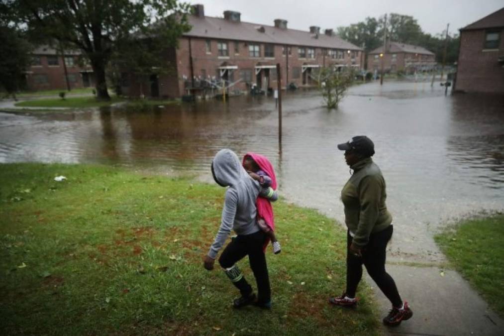 NEW BERN, NC - SEPTEMBER 13: Diamond Dillahunt, 2-year-old Ta-Layah Koonce and Shkoel Collins survey the flooding at the Trent Court public housing apartments after the Neuse River topped its banks during Hurricane Florence September 13, 2018 in New Bern, United States. Coastal cities in North Carolina, South Carolina and Virginia are under evacuation orders as the Category 2 hurricane approaches the United States. Chip Somodevilla/Getty Images/AFP