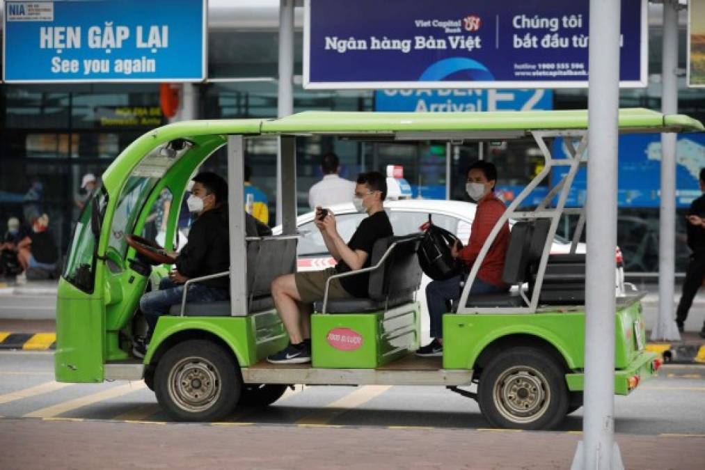 Personas con máscaras faciales en un pequeño autobús de enlace en el aeropuerto internacional de Noi Bai en Hanoi, Vietnam. Foto EFE