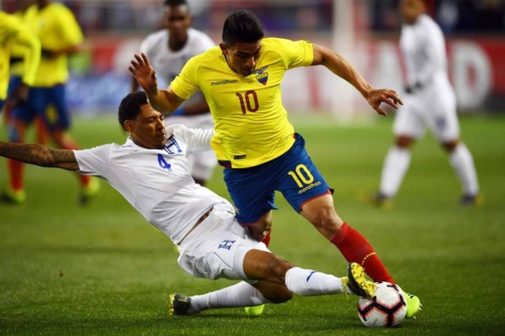 Henry Figueroa se barre para robarle el balón a Ángel Mena.