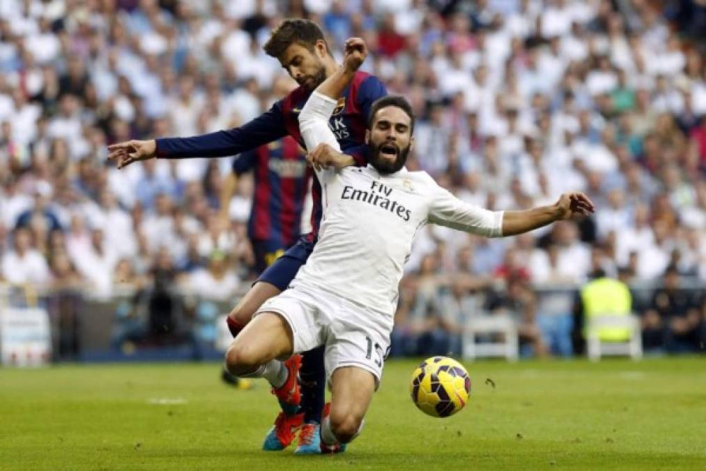 El defensa del Real Madrid, Daniel Carvajal, (d) lucha un balón con el defensa del FC Barcelona, Gerard Piqué, durante el clásico.