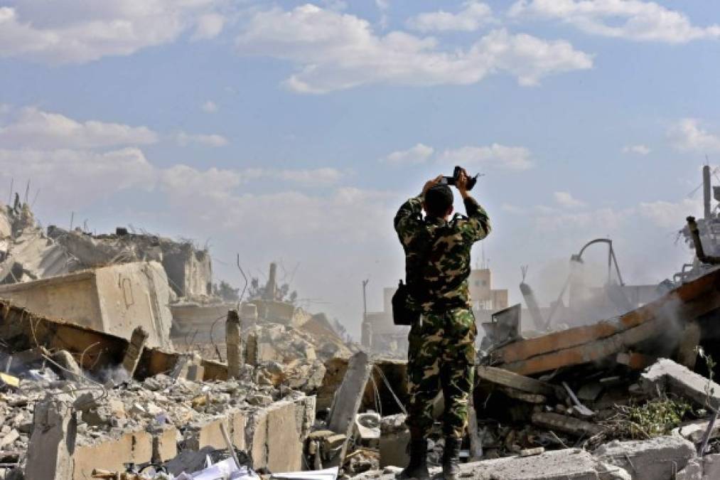 Un soldado sirio inspecciona los restos del complejo del Centro de Estudios Científicos (SSRC), al norte de Damasco capital de Siria.