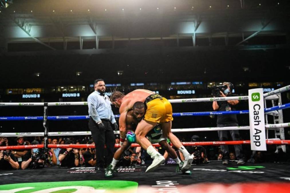 Former world welterweight king Floyd Mayweather (L) dives under YouTube personality Logan Paul (R) as they fight in an eight-round exhibition bout at Hard Rock Stadium in Miami, Florida on June 6, 2021. - Floyd Mayweather predictably dominated YouTube star Logan Paul on Sunday night in an eight round exhibition fight at Hard Rock Stadium in Miami, Florida.<br/>Mayweather, who weighed in at 155 lbs with his opponent tipping the scales at 189.5 lbs, produced a typically slick performance much to the delight of a substantial crowd at the home of the Miami Dolphins. (Photo by CHANDAN KHANNA / AFP)