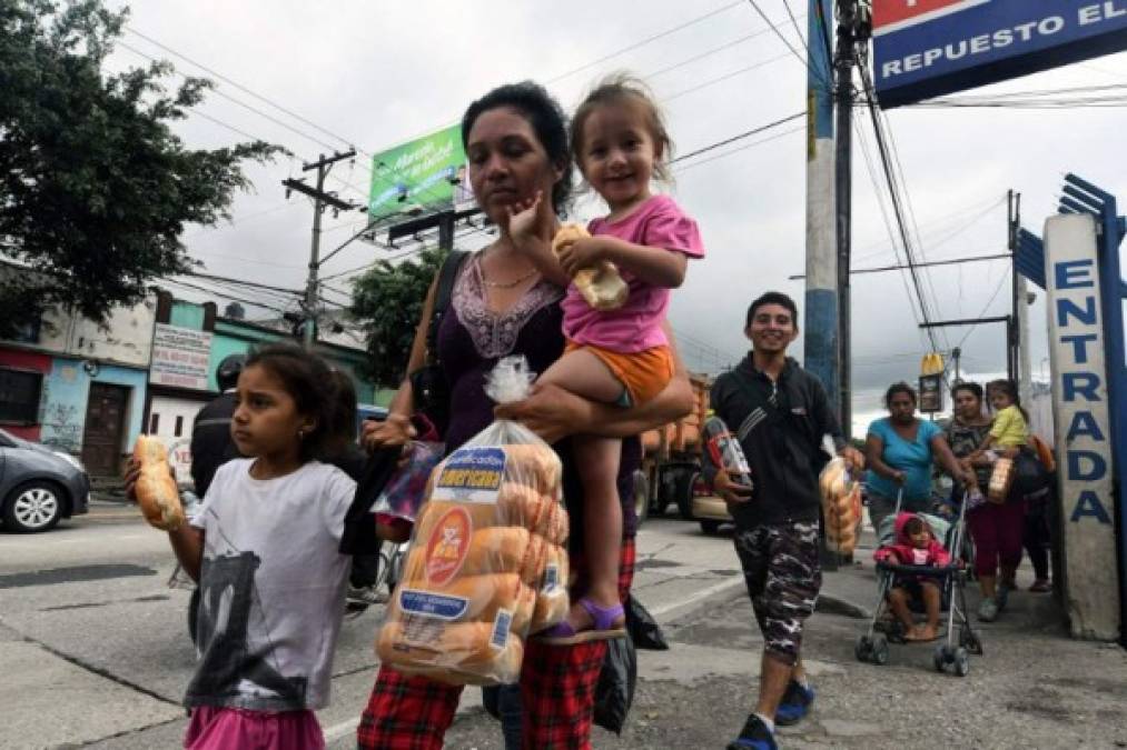 Honduran migrant families taking part in a caravan towards the United States, arrive in Guatemala City, on October 17, 2018. - A migrant caravan set out on October 13 from the impoverished, violence-plagued country and was headed north on the long journey through Guatemala and Mexico to the US border. President Donald Trump warned Honduras he will cut millions of dollars in aid if the group of about 2,000 migrants is allowed to reach the United States. (Photo by ORLANDO SIERRA. / AFP)