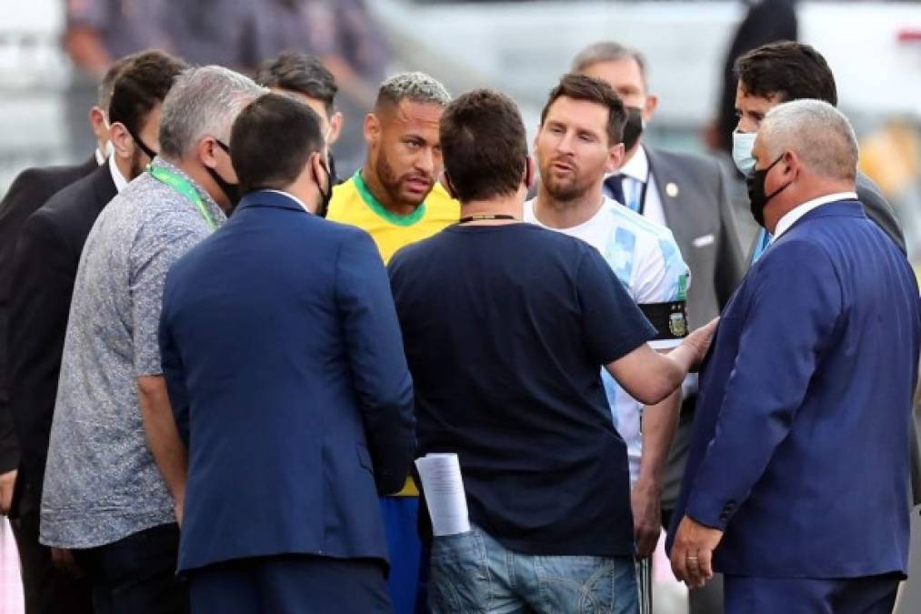 Neymar y Messi hablan con funcionarios de salud brasileños en pleno campo tras ser interrumpido el partido.