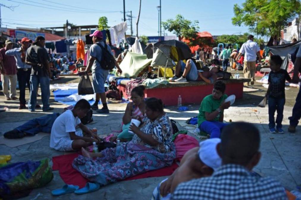 Honduran migrants taking part in a caravan heading to the US, rest in a square during a stop in their journey, in Huixtla, Chiapas state, Mexico, on October 23, 2018. (Photo by Johan ORDONEZ / AFP)