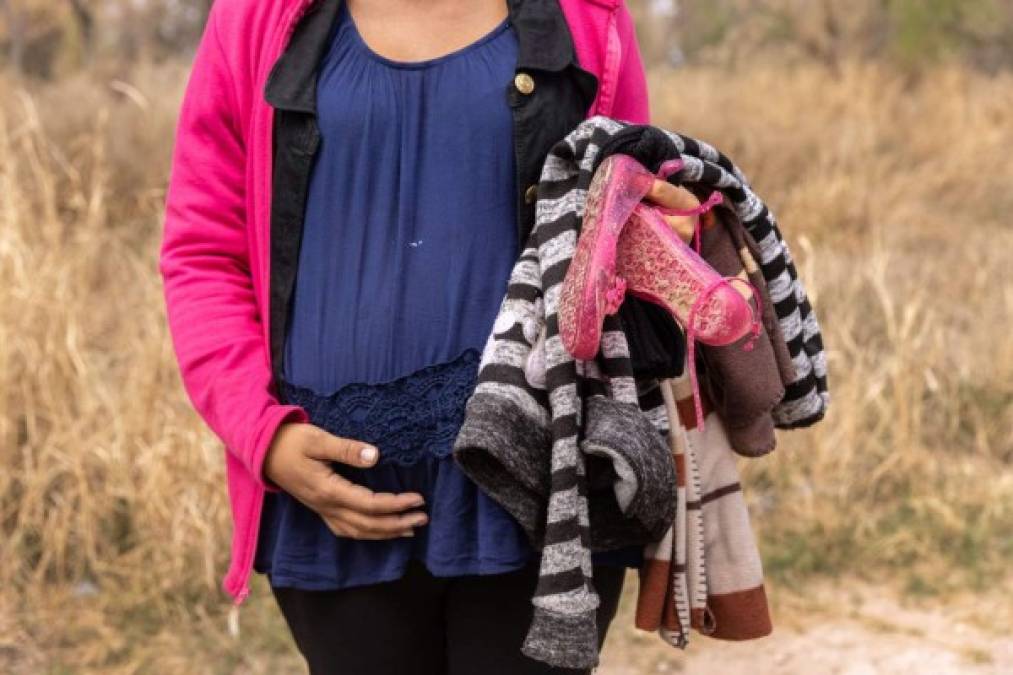 MISSION, TEXAS - MARCH 23: An asylum seeker from Honduras, traveling with her three children while 8 months pregnant, pauses after crossing the Rio Grande from Mexico on March 23, 2021 near Mission, Texas. A surge of migrant families and unaccompanied minors is overwhelming border detention facilities in south Texas' Rio Grande Valley. John Moore/Getty Images/AFP<br/><br/>== FOR NEWSPAPERS, INTERNET, TELCOS & TELEVISION USE ONLY ==<br/><br/>