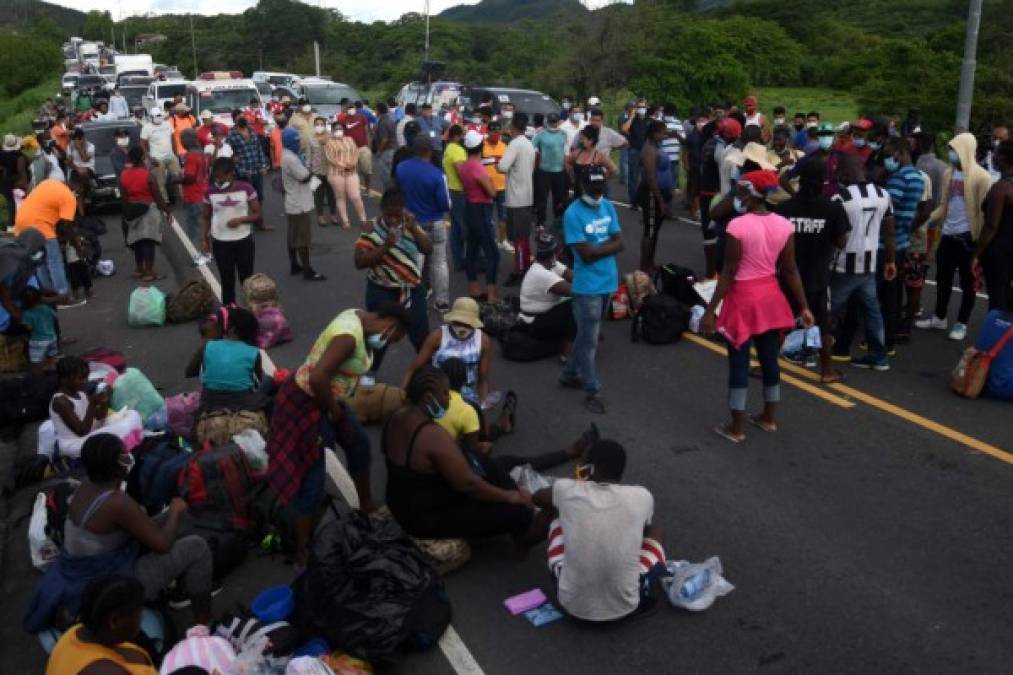 Members of a caravan of migrants from DR Congo, Ghana and Ivory Coast block the Pan-American highway after being stopped by agents of the Honduran National Police near Choluteca, as they were heading to Tegucigalpa to make a stop on their way to Mexico, in Honduras on June 2, 2020 amid the Covid-19 coronavirus pandemic. (Photo by ORLANDO SIERRA / AFP)