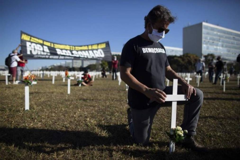 En Brasilia, manifestantes colocaron 1.000 cruces en el césped frente al Congreso para rendir homenaje a las víctimas del coronavirus, con una pancarta que rezaba: 'Bolsonaro, ¡deja de negar!'.