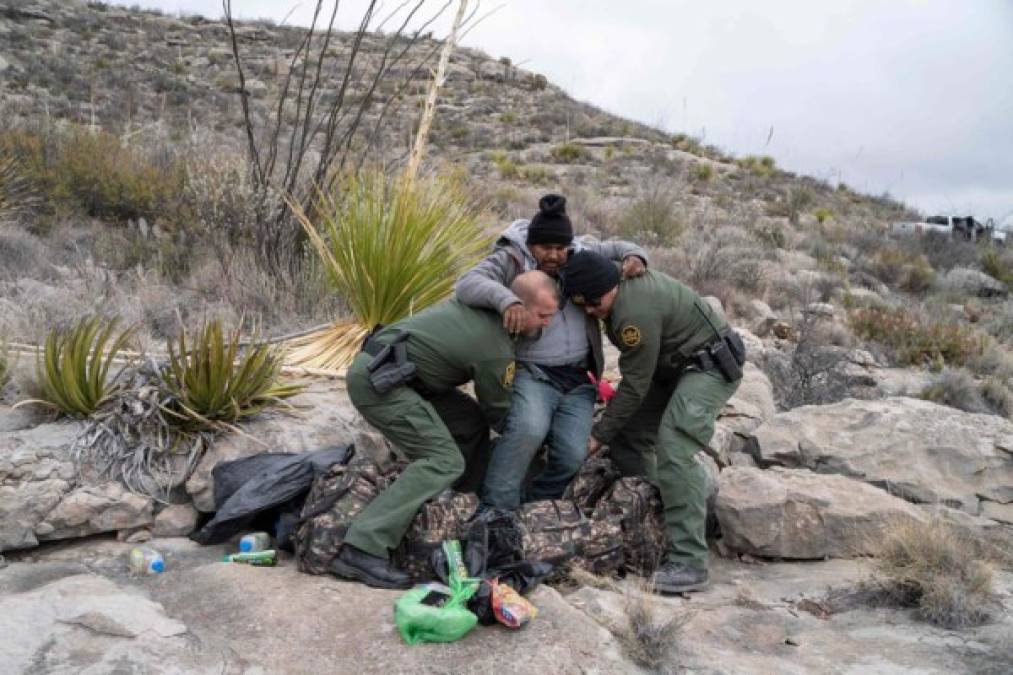 Agentes de la Patrulla Fronteriza de Estados Unidos detectan un destello de color en un empinado cañón y luego identifican a un hombre con un gorro negro recostado en una roca. Texto y fotos: AFP