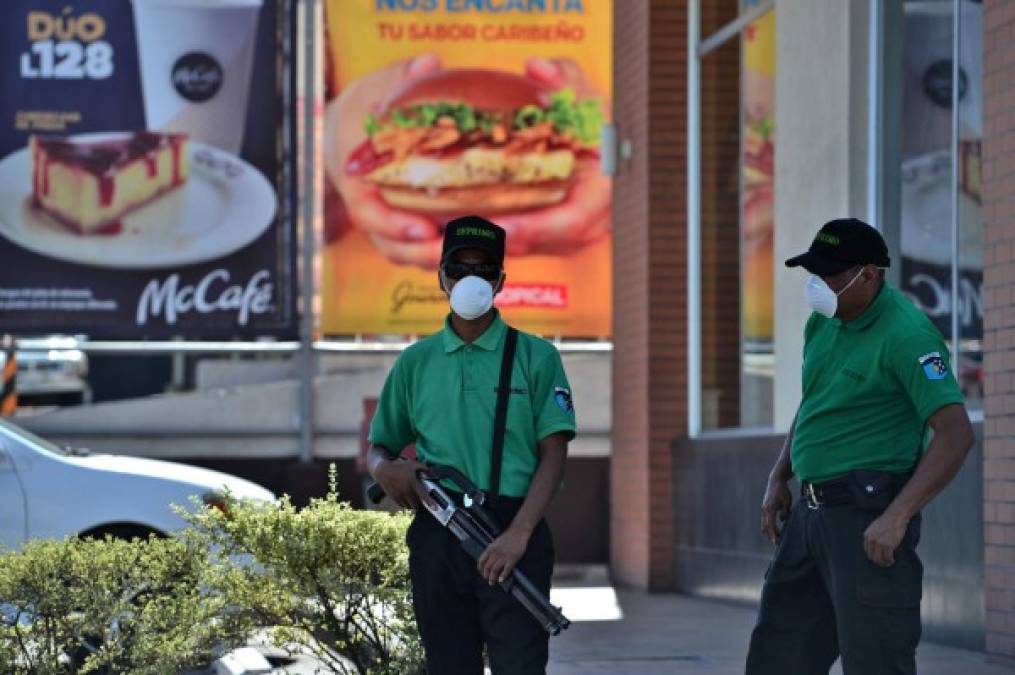 Los guardias brindan seguridad a un restaurante de comida rápida cerrado como medida de precaución contra la propagación del nuevo coronavirus en Tegucigalpa. AFP
