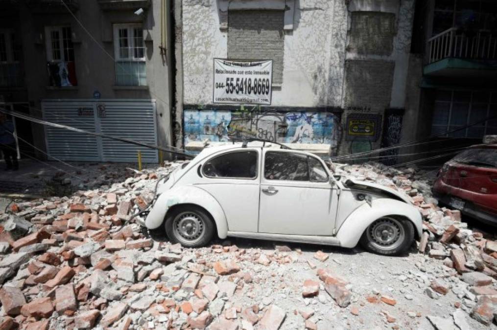 Picture of a car crashed by debris from a damaged building after a quake rattled Mexico City on September 19, 2017.<br/>A powerful earthquake shook Mexico City on Tuesday, causing panic among the megalopolis' 20 million inhabitants on the 32nd anniversary of a devastating 1985 quake. The US Geological Survey put the quake's magnitude at 7.1 while Mexico's Seismological Institute said it measured 6.8 on its scale. The institute said the quake's epicenter was seven kilometers west of Chiautla de Tapia, in the neighboring state of Puebla.<br/> / AFP PHOTO / Alfredo ESTRELLA