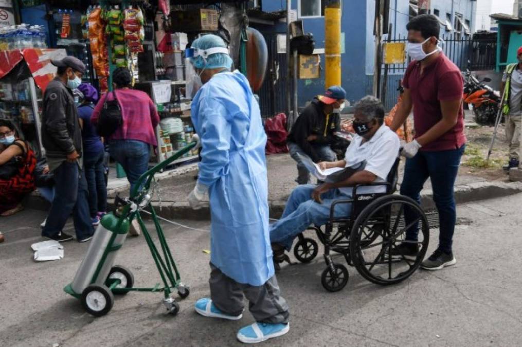 A patient is translated to the tents outside the School Hospital in Tegucigalpa on July 6, 2020 amid the new coronavirus pandemic. - Honduras is facing and increase of COVID-19 cases and deaths with and average of 50 deaths a day. The public and private Health system is collapsed and with few resources to do diagnostic tests. (Photo by ORLANDO SIERRA / AFP)