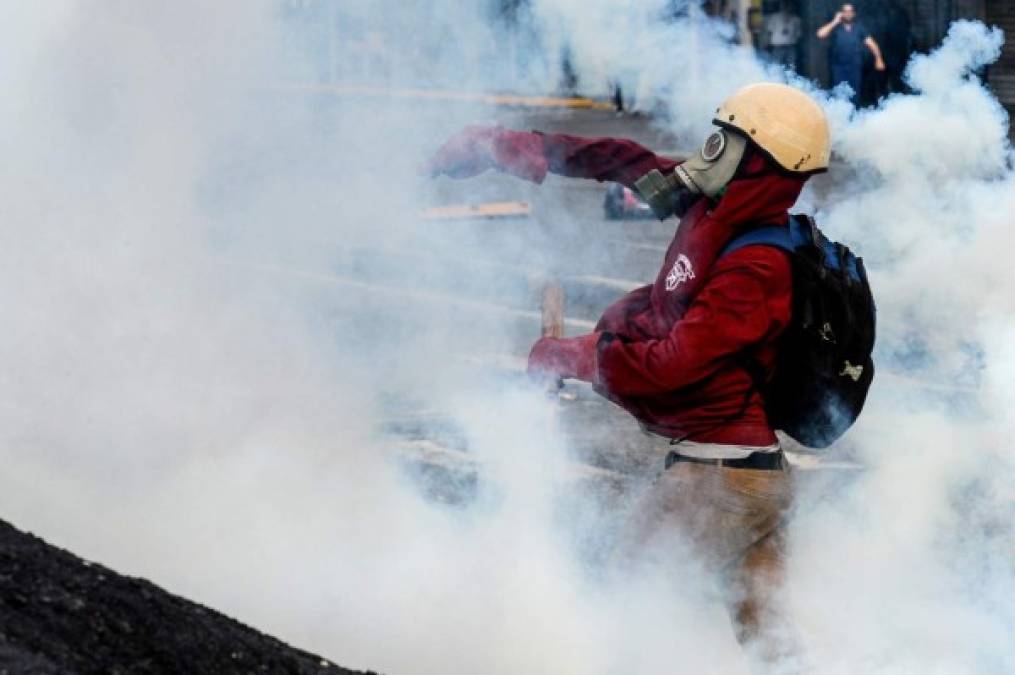 Opposition activists demonstrating against the government of Venezuelan President Nicolas Maduro clash with riot policeice in Caracas on June 26, 2017. <br/>A political and economic crisis in the oil-producing country has spawned often violent demonstrations by protesters demanding Maduro's resignation and new elections. The unrest has left 75 people dead since April 1. / AFP PHOTO / FEDERICO PARRA