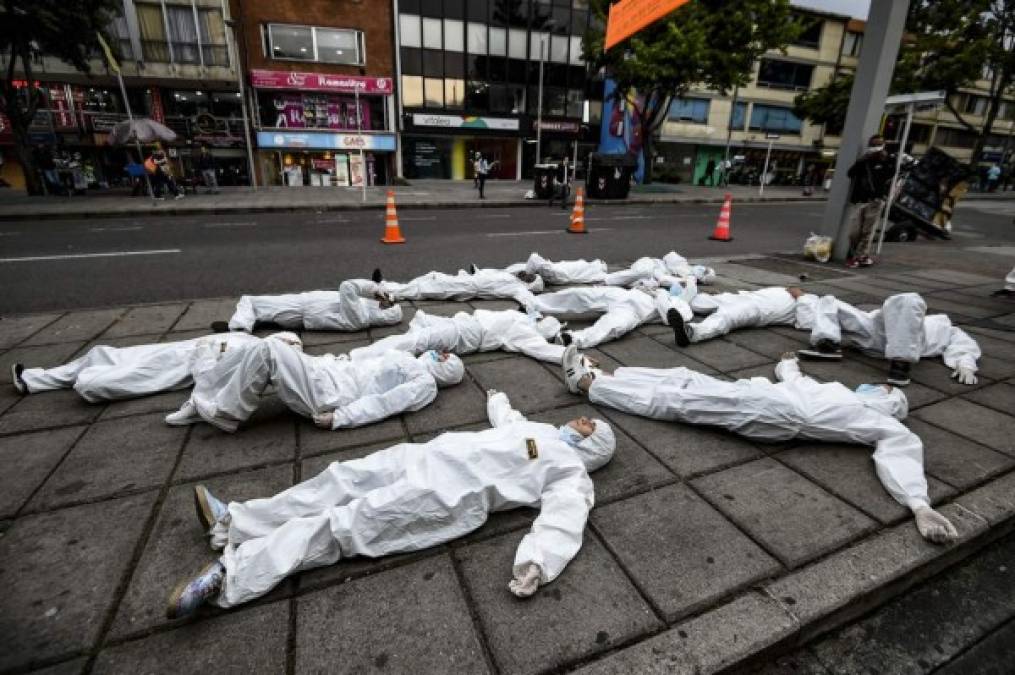 Los jóvenes que usan trajes protectoros participan en una actuación como parte de una campaña de concientización contra la propagación del nuevo coronavirus, COVID-19, en Bogotá. Foto AFP