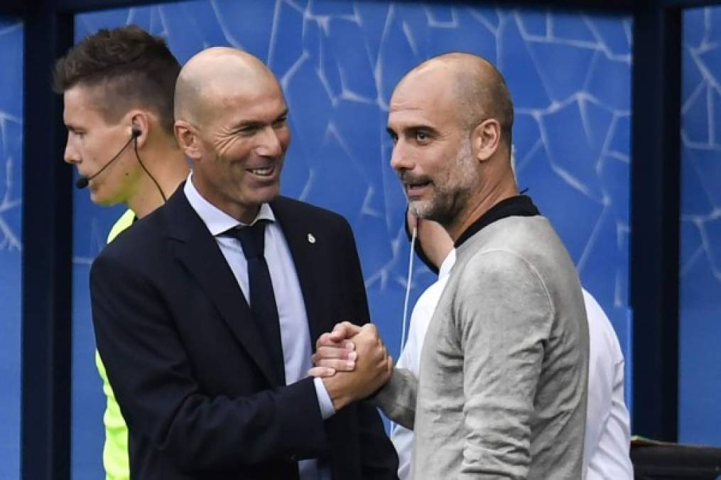 Zinedine Zidane y Pep Guardiola se saludan antes del inicio del partido en el Etihad Stadium.