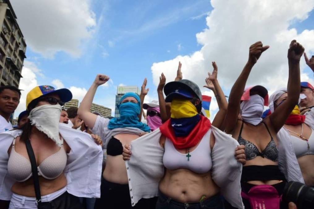 Varias mujeres mostraron los senos en señal de protesta. 'No tenemos escopetas, nuestras armas son las tetas', gritaban a militares.<br/>The death toll since April, when the protests intensified after Maduro's administration and the courts stepped up efforts to undermine the opposition, is at least 36 according to prosecutors.<br/> / AFP PHOTO / RONALDO SCHEMIDT