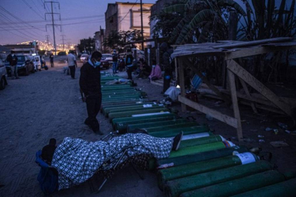 En las afueras de los hospitales de varias localidades, se puede observar como familiares duermen al lado de tanques de oxígeno, acaparados ante la escasez del mismo. Foto AFP