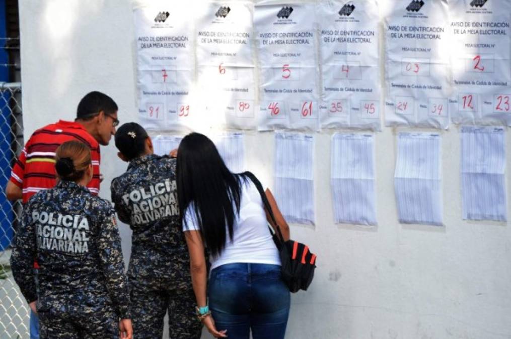 La gente revisa el registro electoral antes de emitir su voto durante las elecciones presidenciales de Venezuela, San Cristóbal. AFP