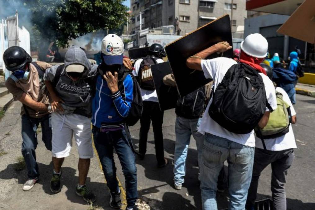Opposition activists demonstrating against the government of Venezuelan President Nicolas Maduro clash with riot police in Caracas on June 26, 2017. <br/>A political and economic crisis in the oil-producing country has spawned often violent demonstrations by protesters demanding Maduro's resignation and new elections. The unrest has left 75 people dead since April 1. / AFP PHOTO / FEDERICO PARRA