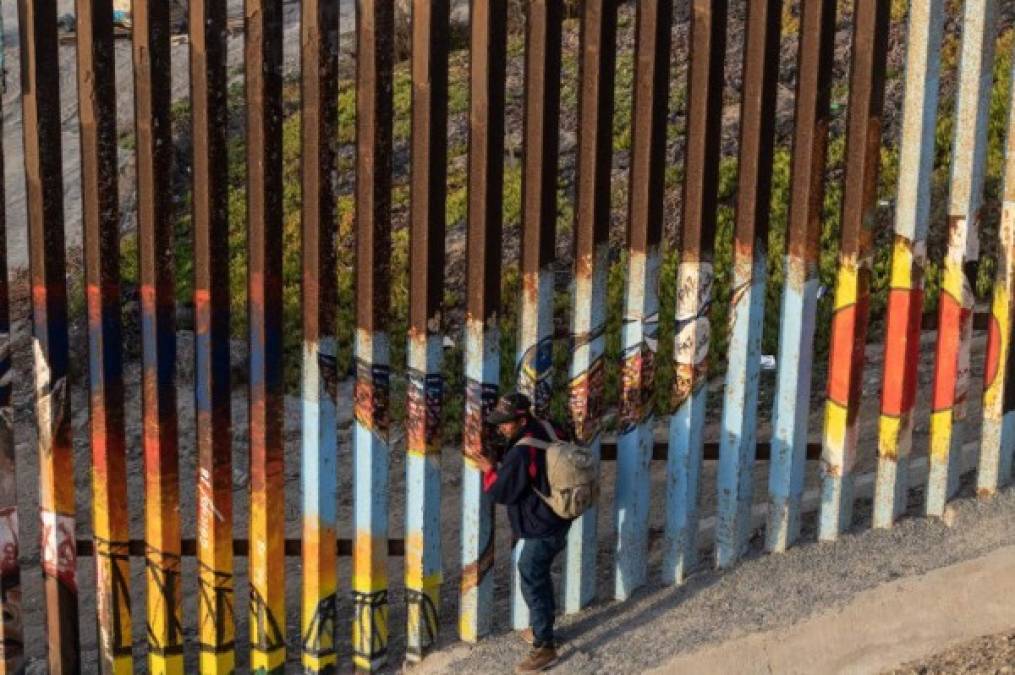 A Central American migrant moving towards the United States in hopes of a better life, is pictured next to the US-Mexico border fence in Playas de Tijuana, Mexico, on November 13, 2018. - US Defence Secretary Jim Mattis said Tuesday he will visit the US-Mexico border, where thousands of active-duty soldiers have been deployed to help border police prepare for the arrival of a 'caravan' of migrants. (Photo by Guillermo Arias / AFP)