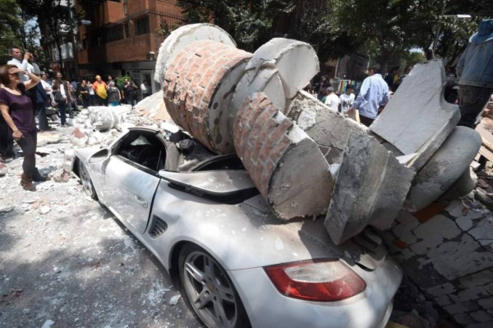 Varias personas observan los daños causados por el sismo.