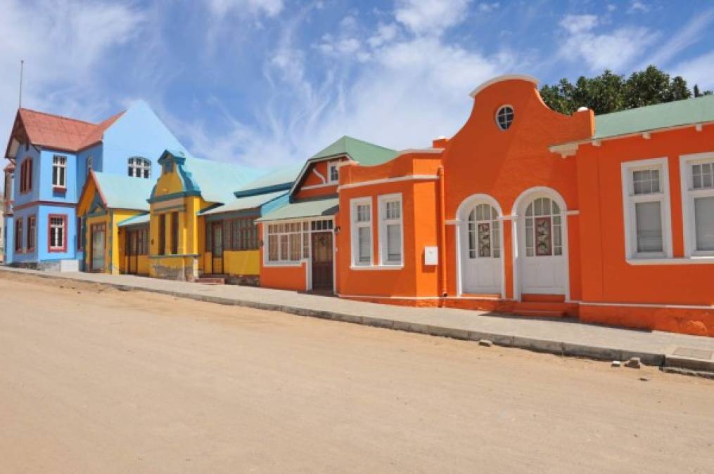 Fila de casas coloridas, anaranjadas, amarillas, azules en Luderitz, una pequeña ciudad en el sudoeste Namibia.