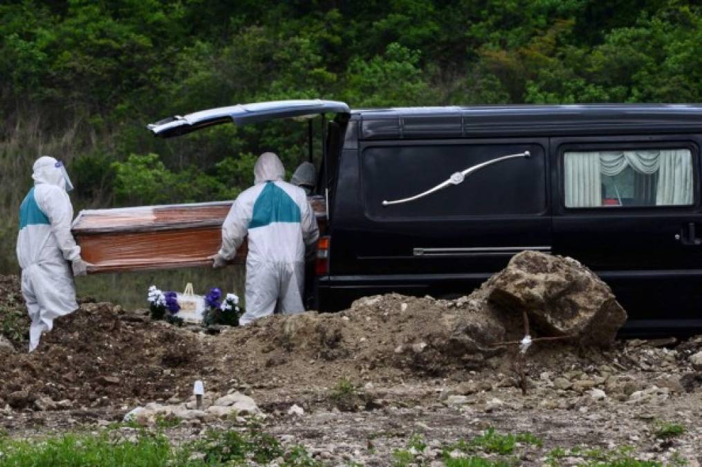 Los hombres que sepultan a las personas fallecidas con COVID-19 visten trajes que cubren todo su cuerpo, guantes, mascarillas y visores protectores. Los cajones llegan forrados con plástico.