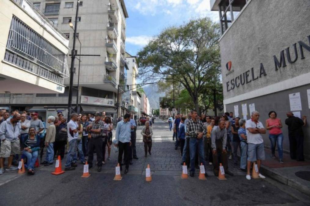 Venezolanos hacen fila frente a una mesa de votación mientras esperan emitir su voto durante las elecciones presidenciales en Caracas. AFP