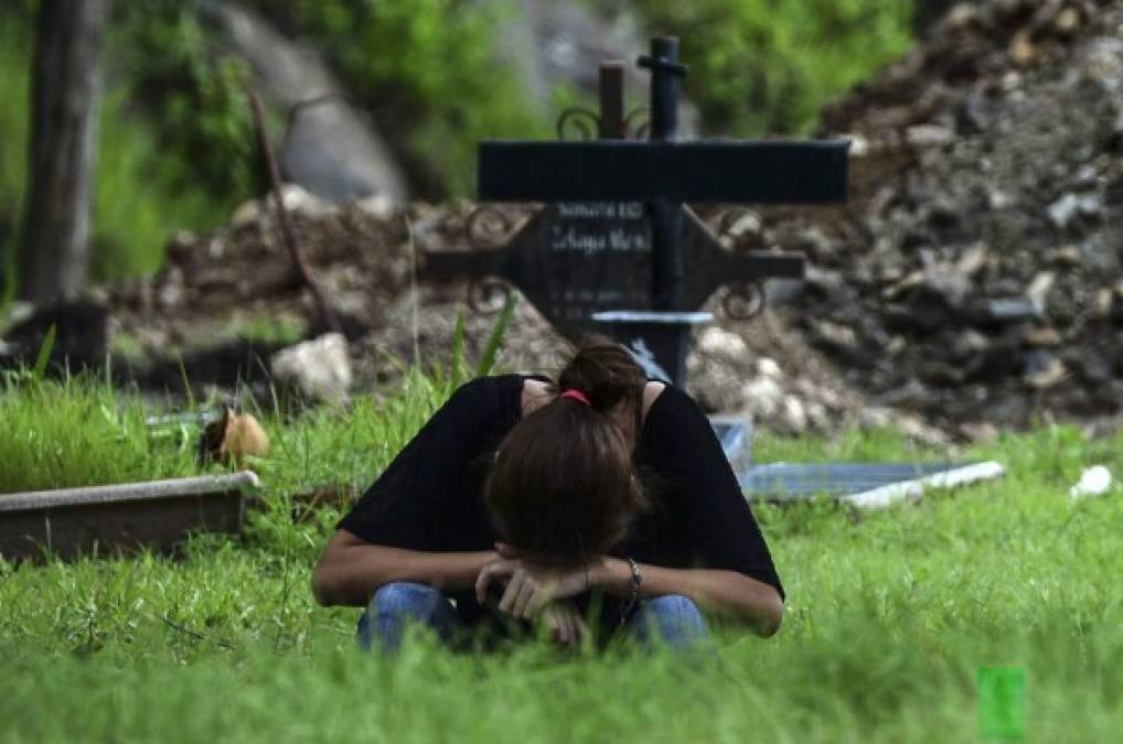 Un familiar llora durante el entierro de una víctima de COVID-19 en Tegucigalpa. AFP