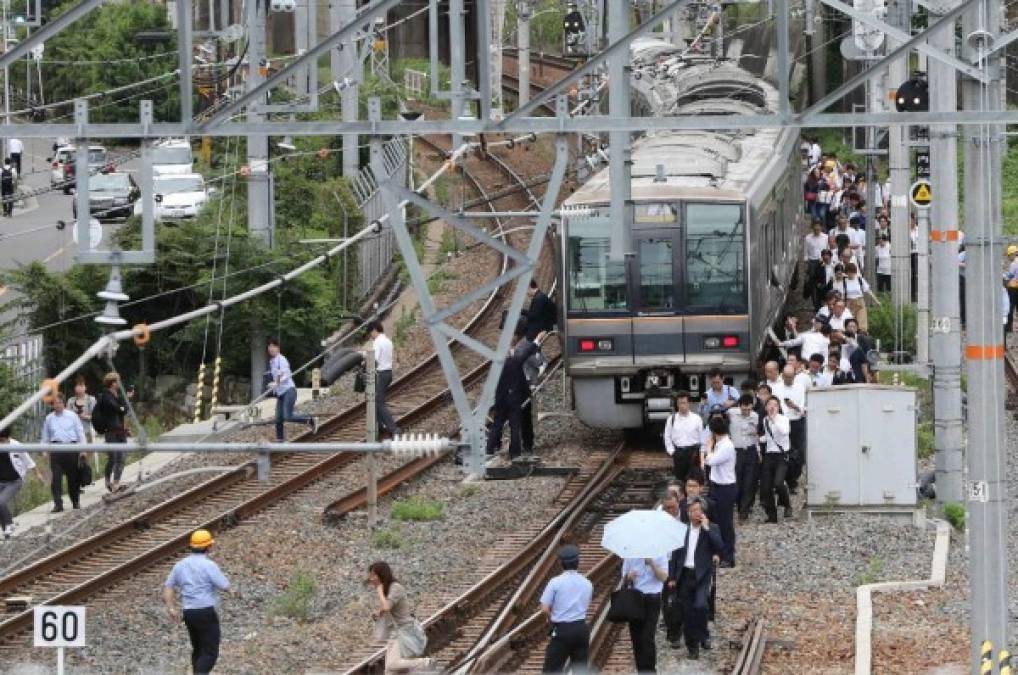 Cientos de nipones que se trasladaban a sus hogares tras la jornada laboral se vieron obligados a caminar sobre las vías luego de que el servicio de trenes quedara suspendido por el fuerte terremoto.