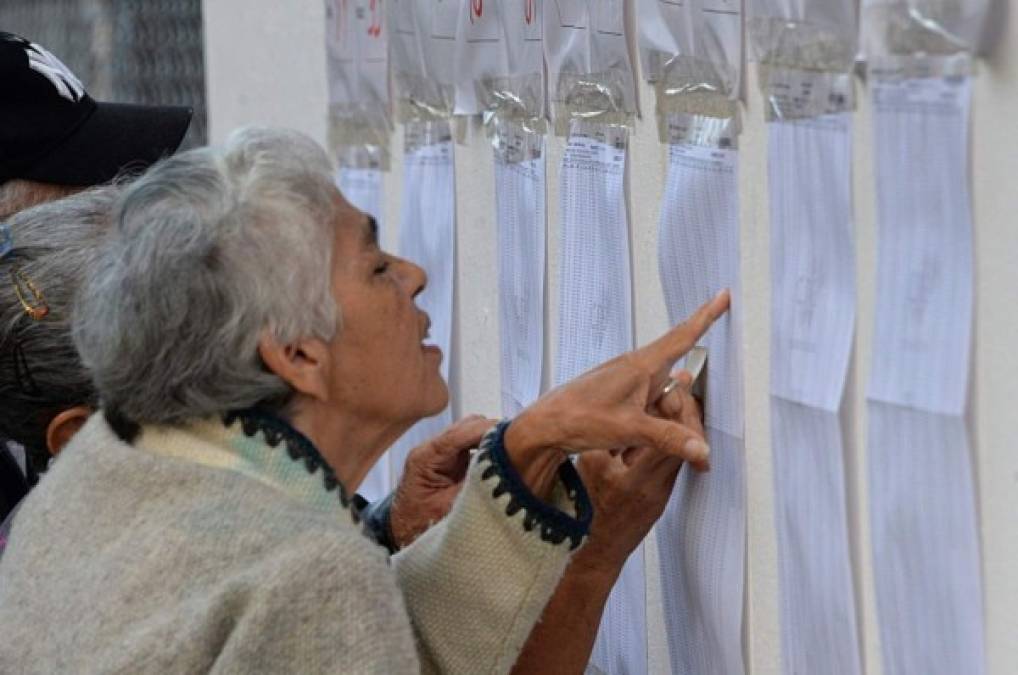 Una señora revisa el registro electoral antes de realizar su voto en San Cristobal, Venezuela. AFP