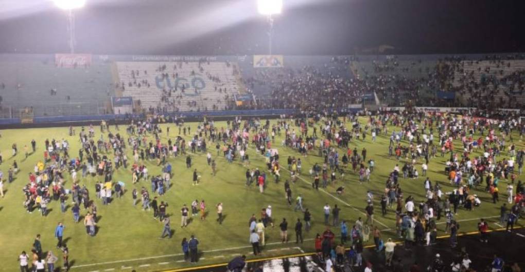 Momento en que los aficionados ingresaron al césped del estadio Nacional luego de que la Policía Nacional hizo uso de bombas lacrimógenas.