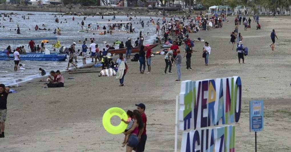 Hondureños disfrutan de un día de playa durante la Semana Santa a pesar de la pandemia del nuevo coronavirus, en la ciudad caribeña de Puerto Cortés. (FOTOS AFP)