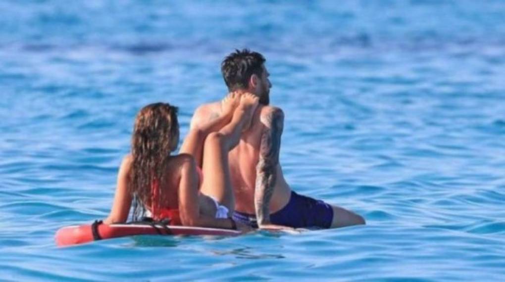 Messi y Antonella se relajan en una tabla de surf.