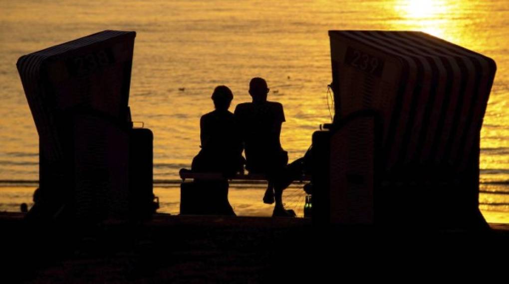 ROMANCE. A la puesta del sol. Una pareja contempla el atardecer en una playa de Norderney, Alemania.