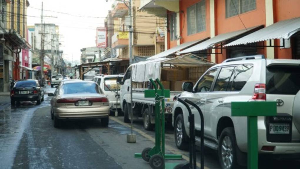 Esta fotografía muestra que hasta los trocos son usados para guardar los espacios de los vehículos de los dueños de negocios.