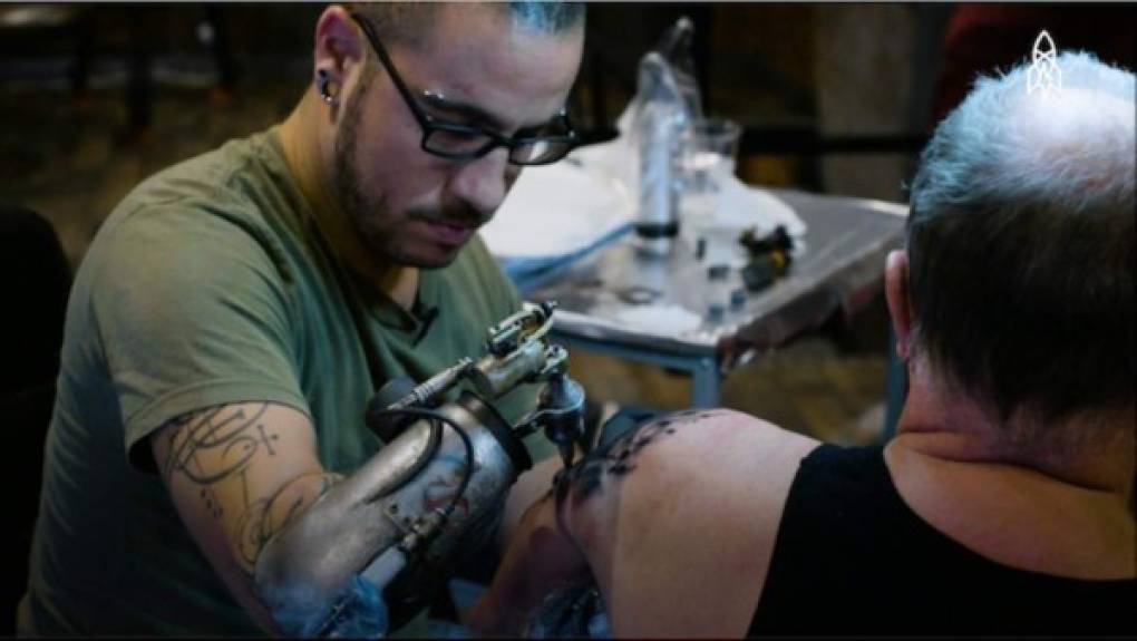 Jc Sheitan Tenet, mientras tatúa a un cliente.