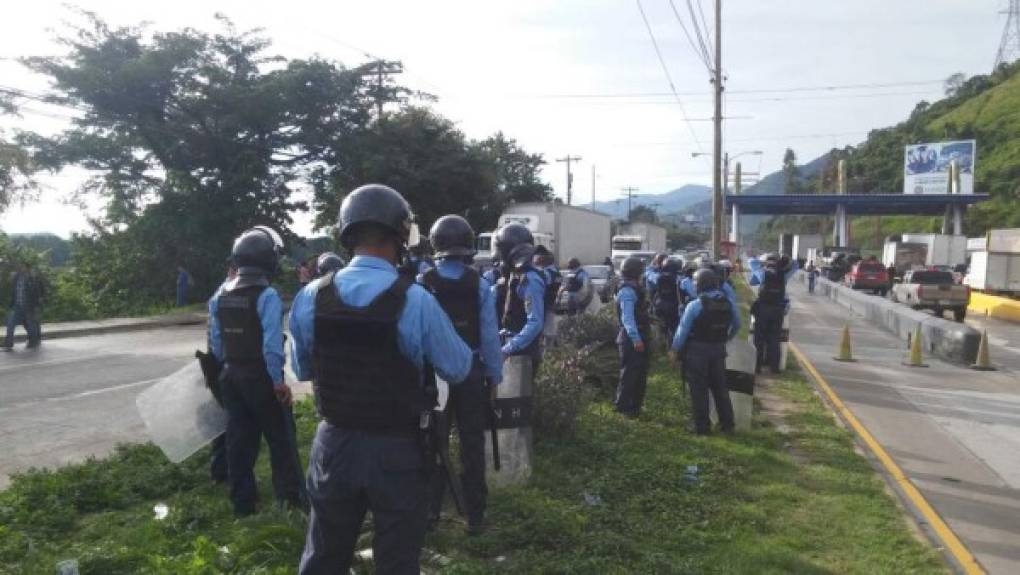 Policías antimotines se disponen a desalojar a los conductores que mantienen bloqueado el bulevar de sur de San Pedro Sula.