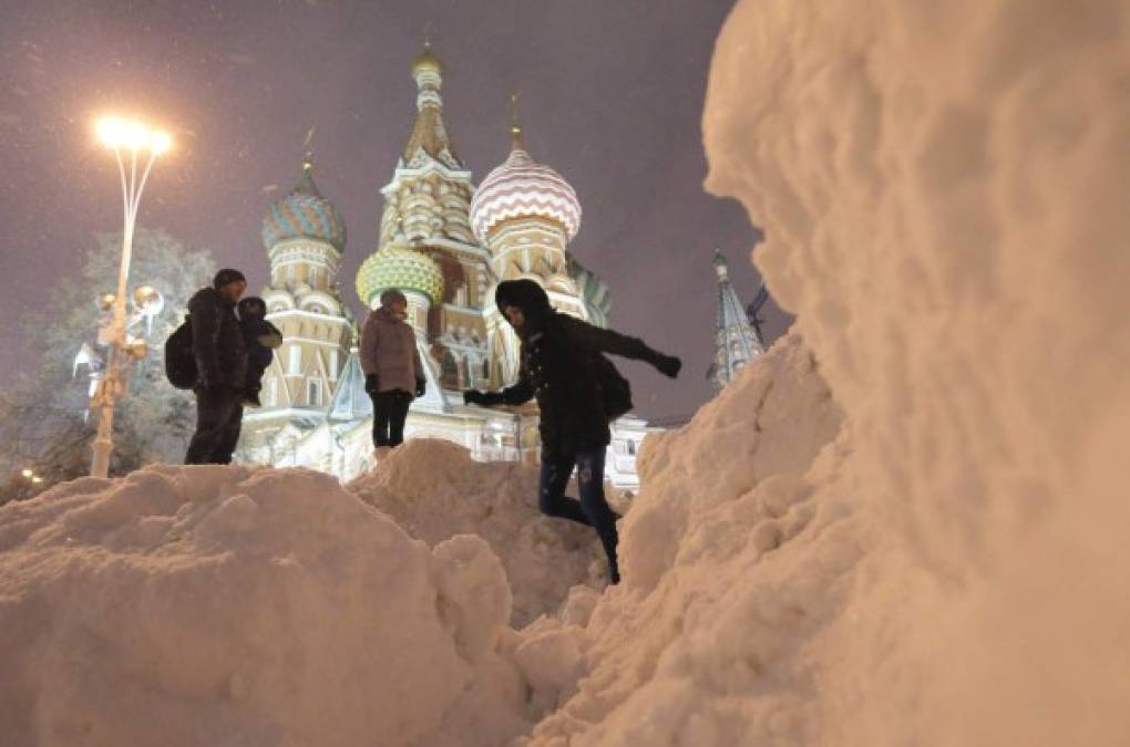 RUSIA. La Navidad llega a Moscú. Un grupo de personas disfrutan de la nieve en la plaza roja de Moscú tras una fuerte nevada. Foto: EFE/Maxim Shipenkov