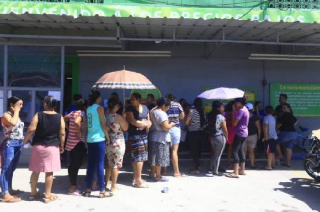 Ciudadanos hacen fila en un supermercado de San Pedro Sula. Se debe evitar en lugar públicos la presencia de niños, ancianos y familias enteras en los supermercados.