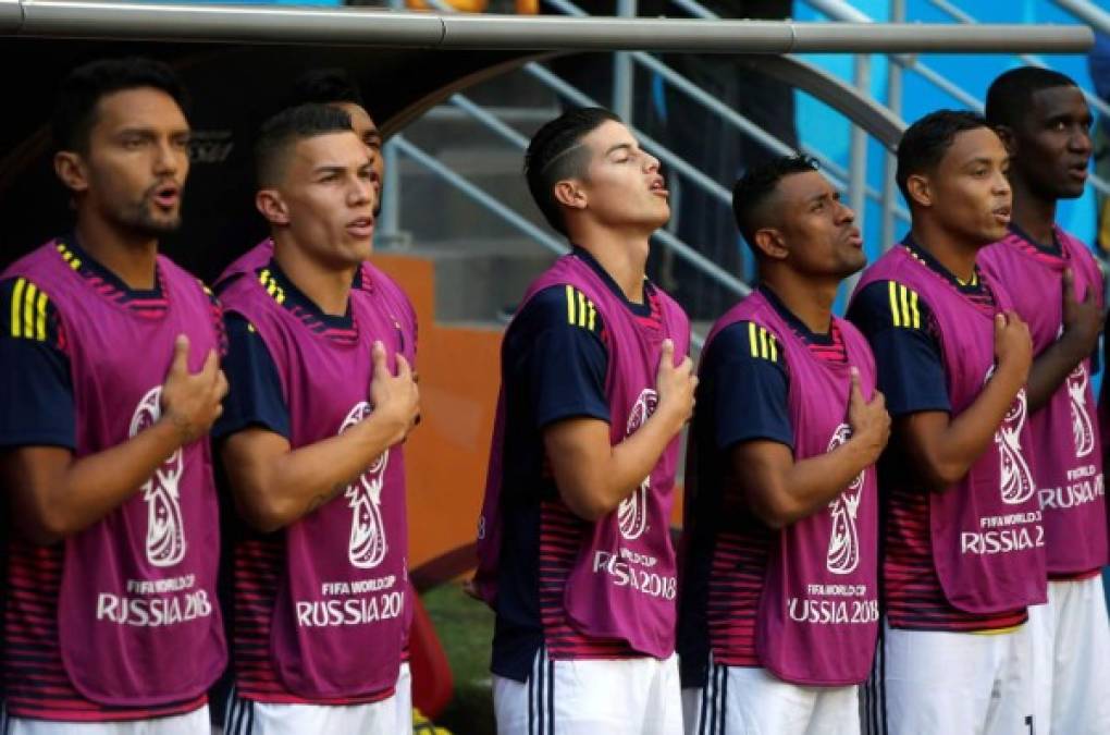 Los jugadores suplentes de Colombia, entre ellos James Rodríguez, cantando el himno nacional de su país. Foto AFP