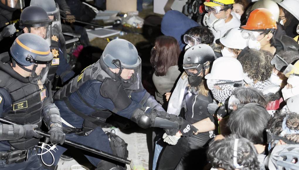 Vistiendo cascos blancos, los manifestantes se tomaron de las manos y formaron una fila frente a los policías, que se llevaron detenidos a varios de ellos. 