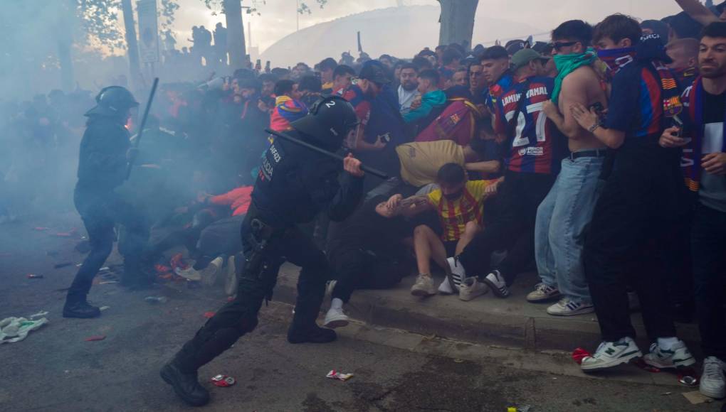 Seguidores del FC Barcelona se enfrentan a miembros de las fuerzas de seguridad a la llegada del autobús que transportaba a los jugadores antes del inicio del encuentro de vuelta correspondiente a los cuartos de final de la UEFA Liga de Campeones. 
