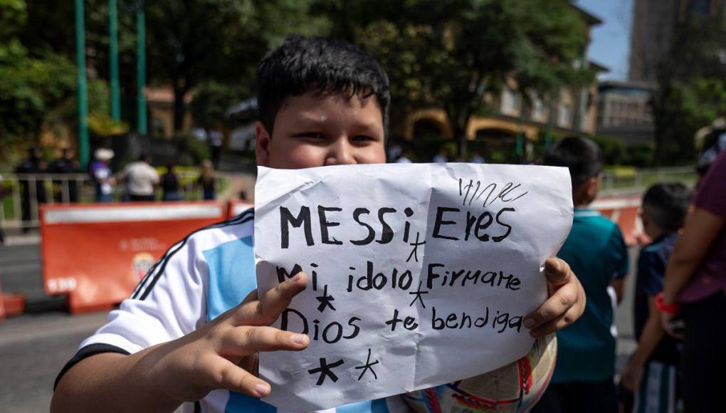 Un pequeño mexicano con un cartel en la que le señala que es su “ídolo.”