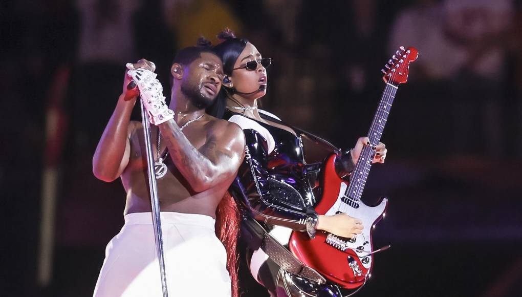  Usher junto a la artista H.E.R. Ella entró al escenario tocando un corto solo de guitarra, con el cual arrancó aplausos de los presentes. 