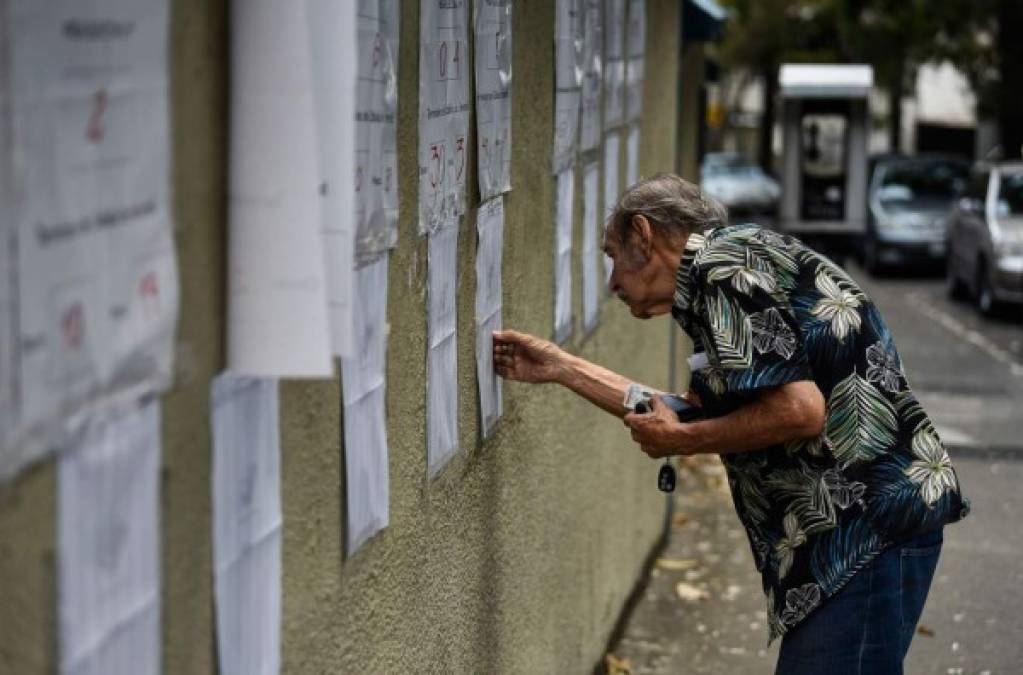 Un hombre revisa el registro electoral antes de emitir su voto durante las elecciones presidenciales de Venezuela, en Caracas. AFP