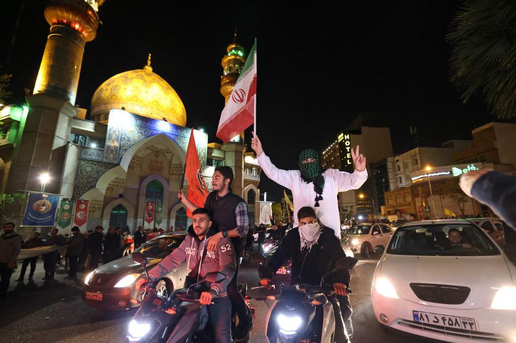 Los manifestantes ondean la bandera de Irán y las banderas palestinas mientras se reúnen en la Plaza Palestina en Teherán el 14 de abril de 2024, después de que Irán lanzara un ataque con aviones no tripulados y misiles contra Israel.