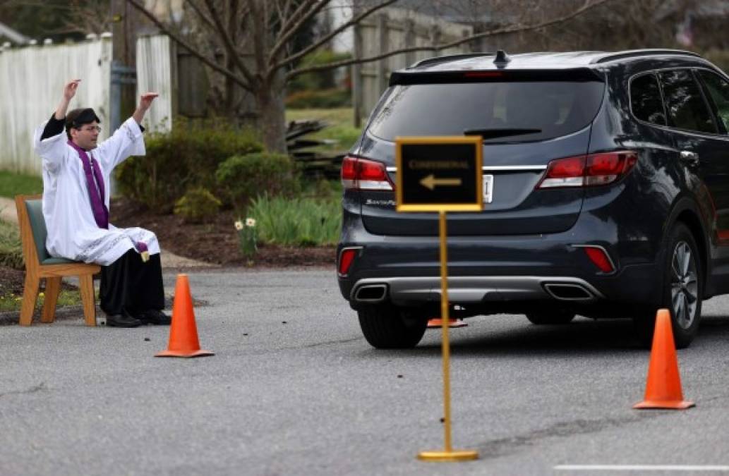 Tras el cierre de las iglesias en Estados Unidos, el sacerdote Scott Holmer de la Iglesia St. Edward ofrece un confesionario al estilo de auto servicio y a una distancia social de dos metros para evitar contagios de coronavirus.