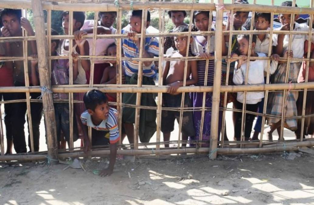 Bangladesh. En busca de alimentos. Refugiados musulmanes atraviesan una barricada de bambú para recolectar alimentos cocinados en el campamento de Thankhali.